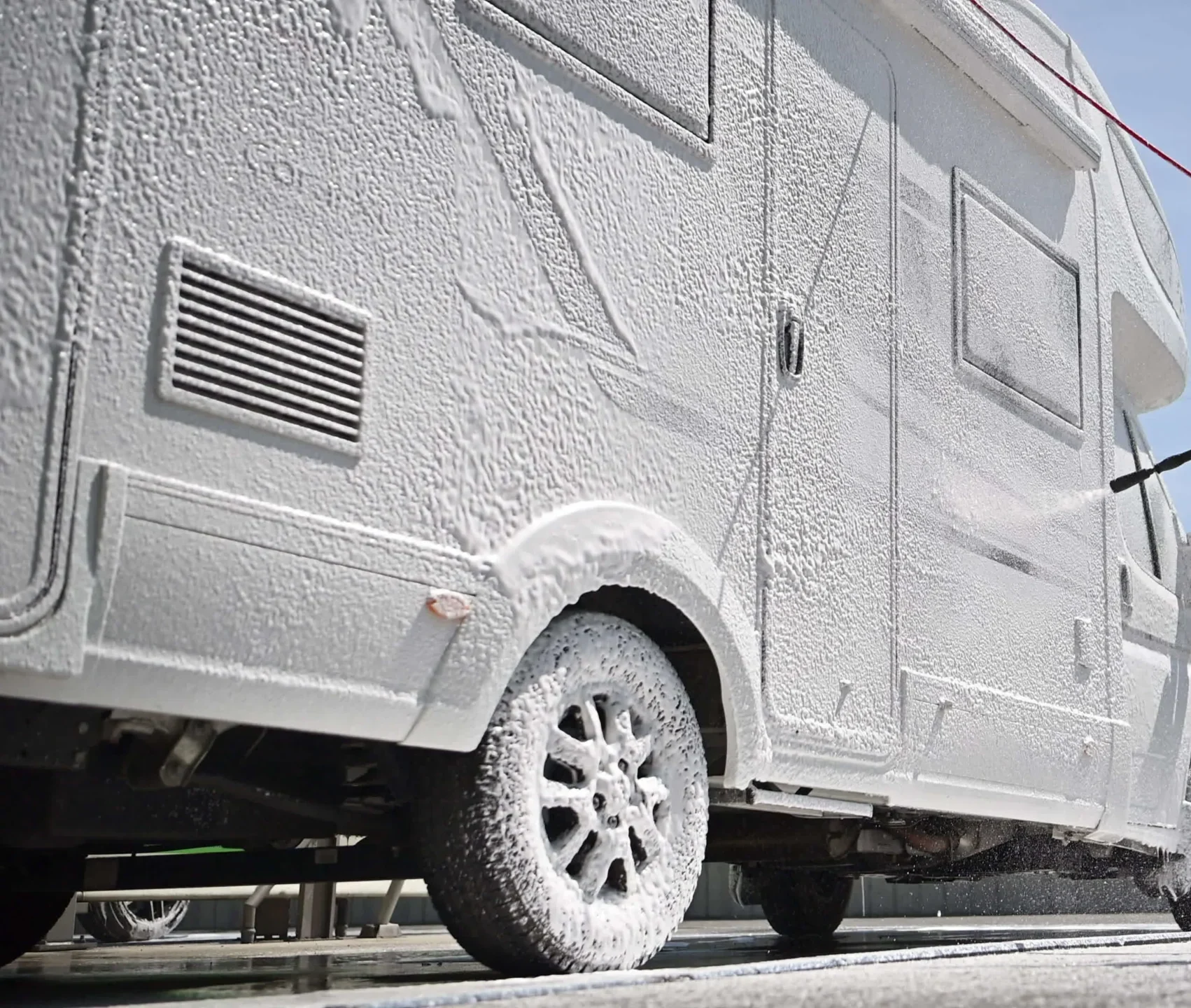 Men washing modern class c camper van rv with active foam video